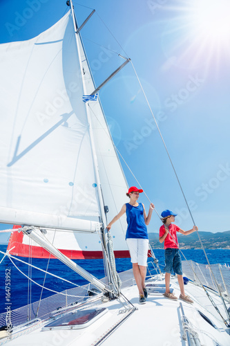 Boy with his sister on board of sailing yacht on summer cruise. Travel adventure, yachting with child on family vacation.