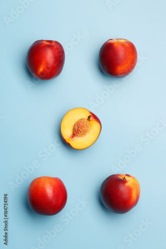 A few ripe nectarines on a blue background