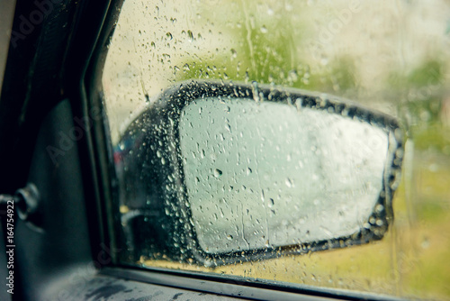 Road view through car window with rain drops, Driving in rain.