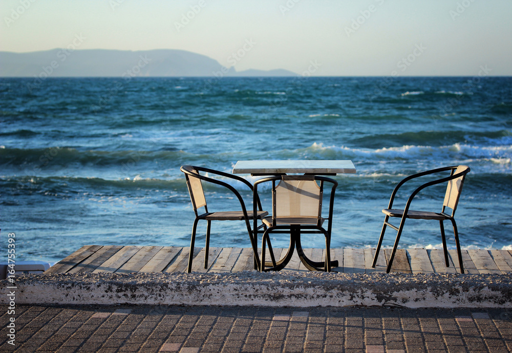 Table and chairs on the beach in the early summer morning
