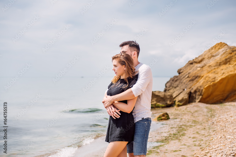 Beautiful Couple At Beach.Outdoor portrait happy beautiful couple,couple having fun by sea,enjoy vacation,trendy hipster look,happiness,love,summer holidays,man touching girlfriend,tan