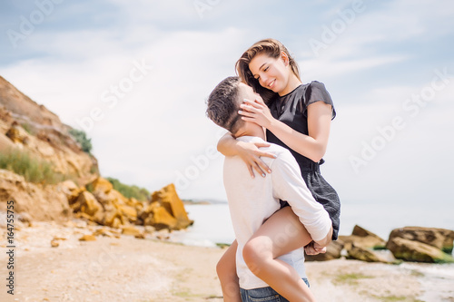 Beautiful Couple At Beach.Outdoor portrait happy beautiful couple,couple having fun by sea,enjoy vacation,trendy hipster look,happiness,love,summer holidays,man touching girlfriend,tan
