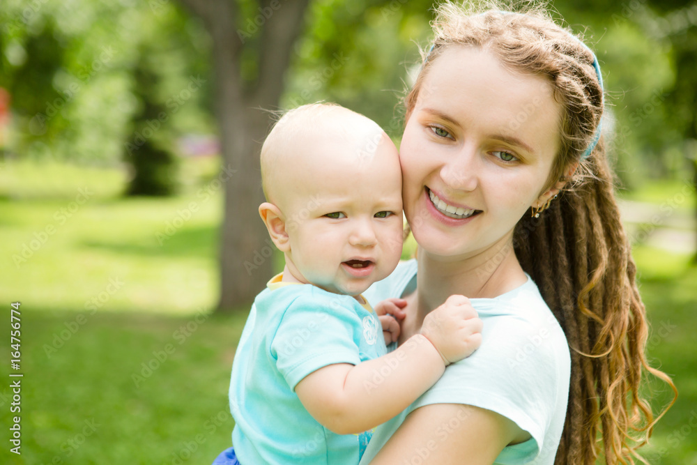 Portrait of happy loving mother and her baby boy playing in park. happy family outdoors. Portrait of happy loving mother and her baby boy playing in park. happy family outdoors.