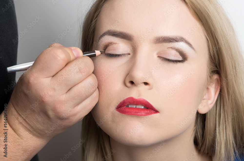 Girl with closed eyes getting makeup on eyelids Girl with closed eyes getting makeup on eyelids