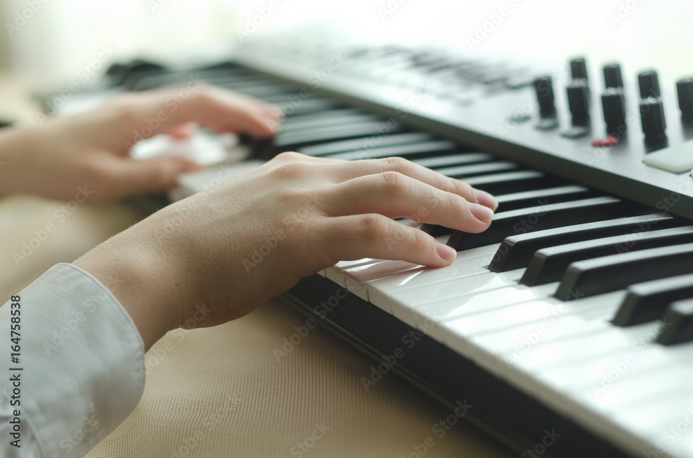Fototapeta premium Female are playing on the synthesizer
