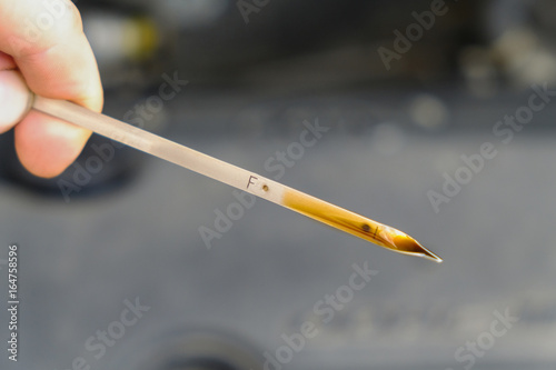 checking the oil level in a car engine
