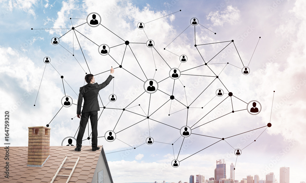 Businessman on house roof presenting networking and connection concept. Mixed media Businessman on house roof presenting networking and connection concept. Mixed media