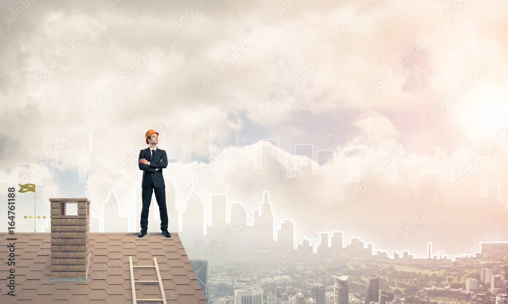 Engineer man standing on roof and looking away. Mixed media Engineer man standing on roof and looking away. Mixed media