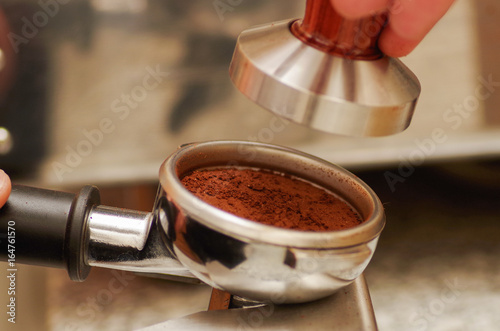 Fototapeta Naklejka Na Ścianę i Meble -  Close up of chocolate powder with cinnamon in a coffee strainer, in a blurred background