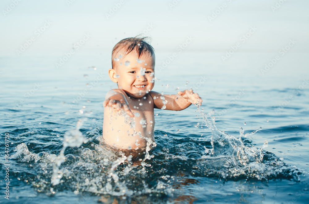 Happy baby playing in the sea