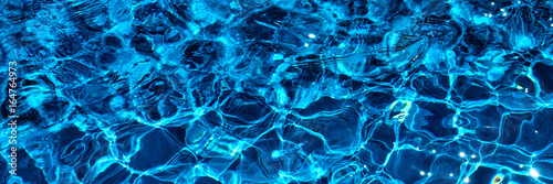 Water in swimming pool with sun reflection. Blue water. Water abstract background