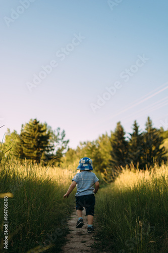 Toddler running through a field in summer
