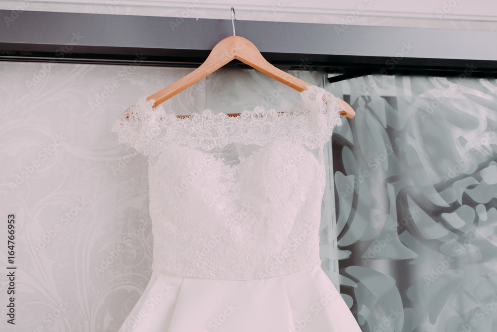 Naklejka premium White beautiful bridal dress with lace on a wooden shoulders, before wedding ceremony