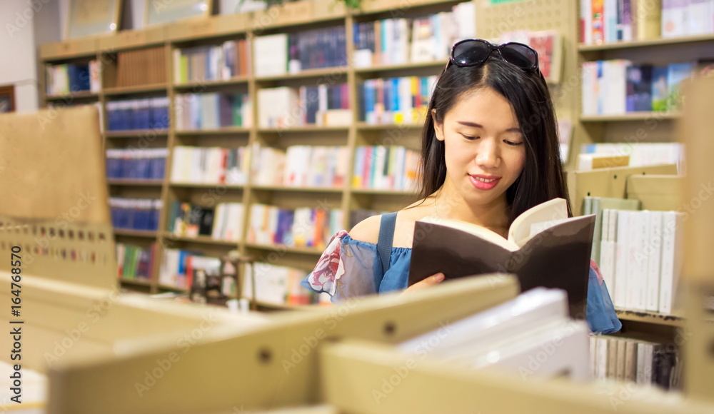 Asian girl reading in a bookstore Asian girl reading in a bookstore