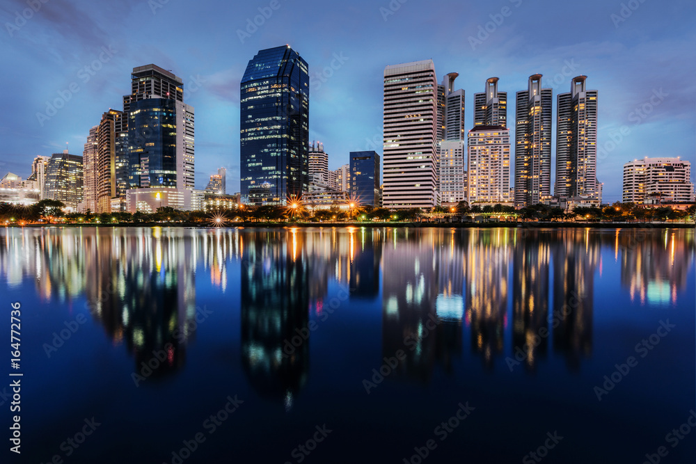 Skyscraper business district of bangkok city view with water reflection of skyline, taken from Benjakitti park on Ratchadapisek Road in Bangkok, Thailand
