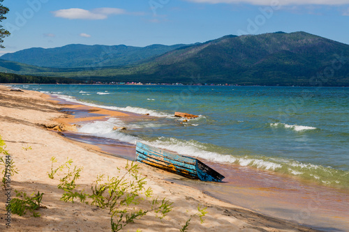Sandy shore of a Baikal with a wooden boat