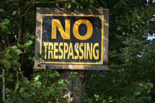 Old Yellow and Black No Trespassing Sign