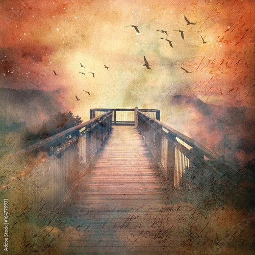 Fototapeta Atmospheric scene of a flock of birds and wooden bridge leading into low clouds in a surreal starry sky above misty mountains. Vintage, grunge textured image.