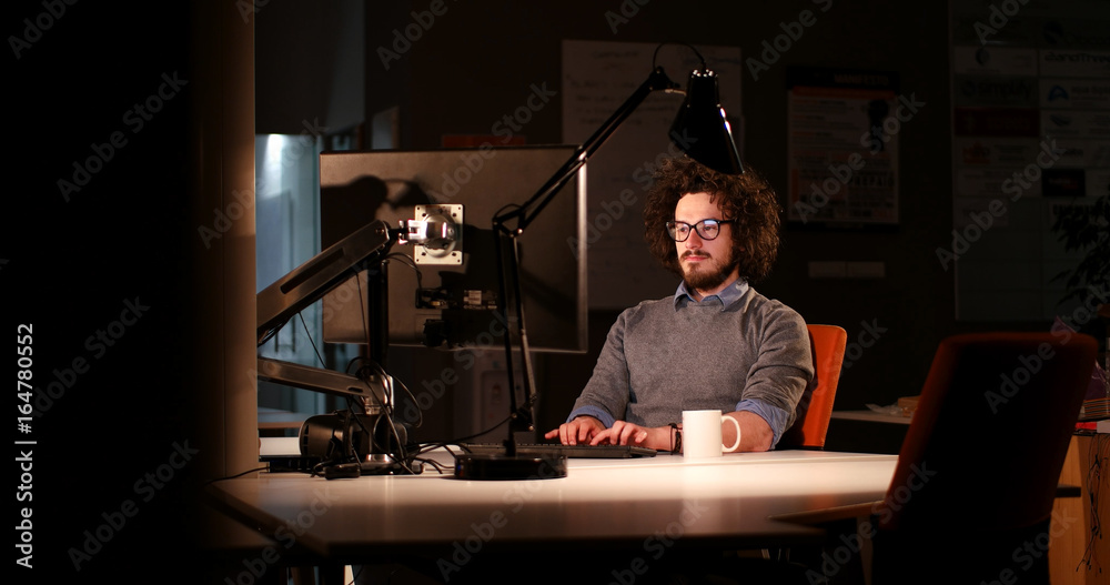 man working on computer in dark office man working on computer in dark office