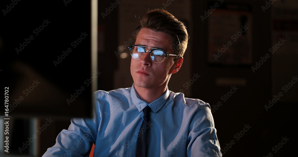 man working on computer in dark office man working on computer in dark office