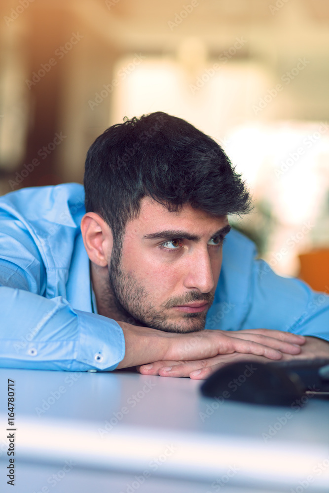 Portrait of a depressed office worker laying on his desk and thinking Portrait of a depressed office worker laying on his desk and thinking