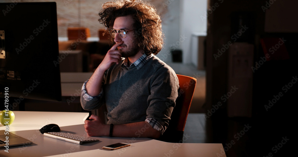 man working on computer in dark office