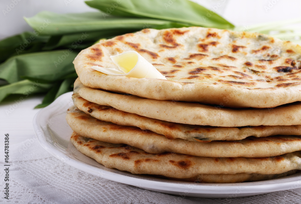 Khychiny – traditional caucasian flatbread filled with сheese and herbs. Khychiny – traditional caucasian flatbread filled with сheese and herbs.