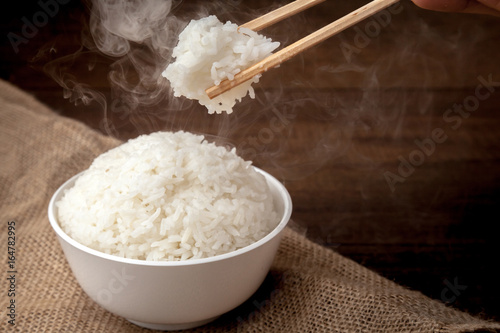 Obraz na płótnie Eating rice by using chopsticks on wooden background w salonie