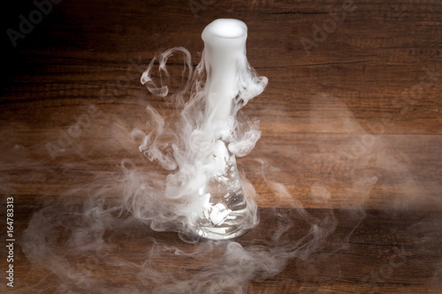 Obraz na płótnie Smoke from putting dry ice in the water, in transparent vest, on wooden background, dark and mysterious style w salonie
