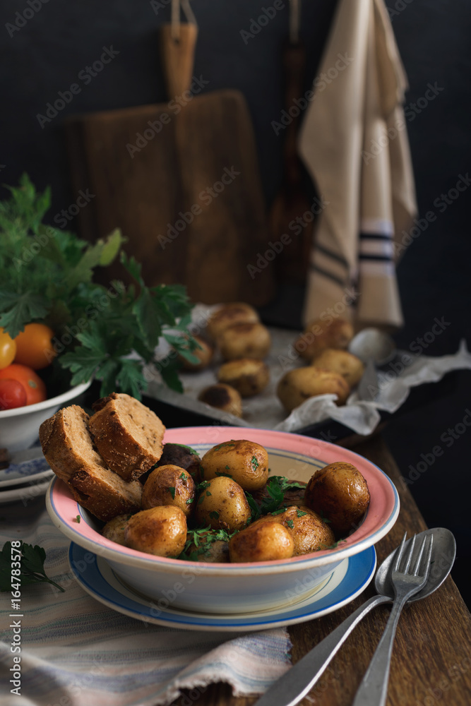 Plate with new fried potatoes on rustic wooden table