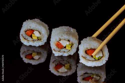 traditional fresh japanese sushi rolls on black background