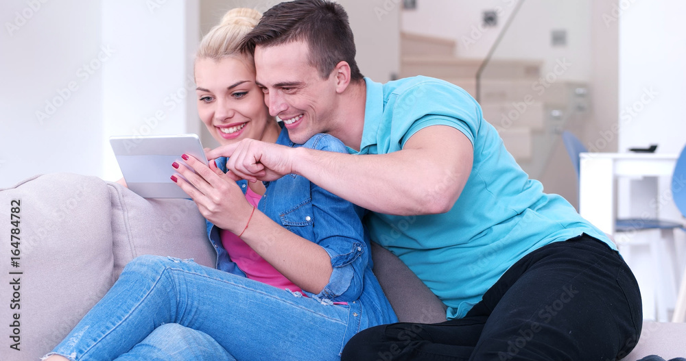 Obraz premium couple relaxing at home with tablet computers