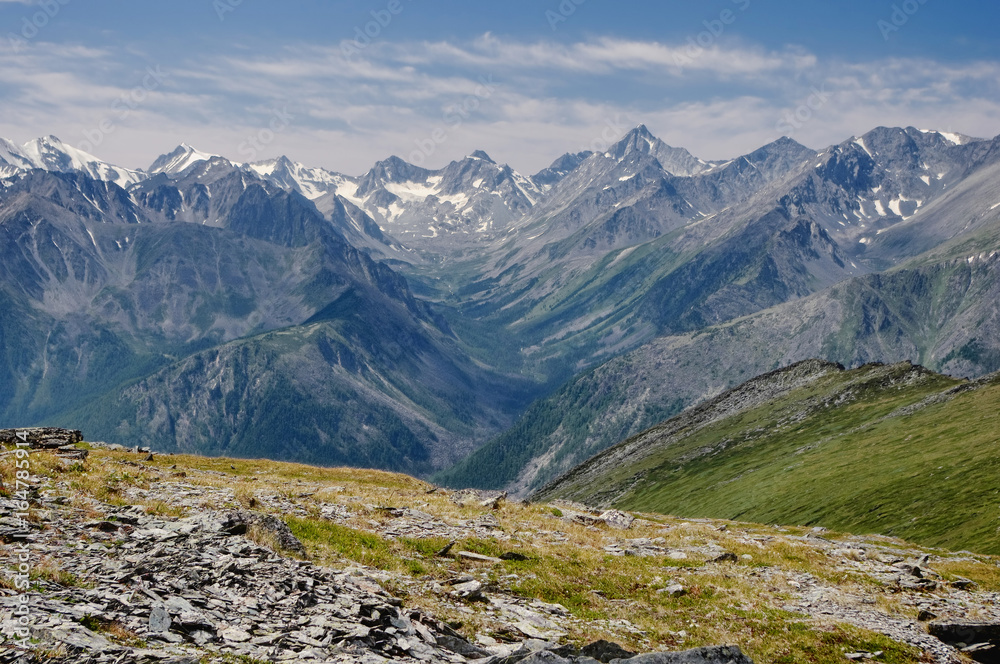 Mountain valley on the background of ranges and snow peaks view from above top height with rocks and alpine meadow in the foreground Altai Mountains Siberia, Russia Mountain valley on the background of ranges and snow peaks view from above top height with rocks and alpine meadow in the foreground Altai Mountains Siberia, Russia