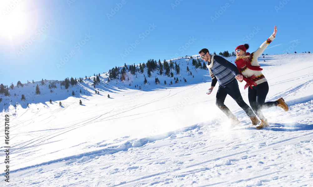 Cheerful young couple having fun in winter park