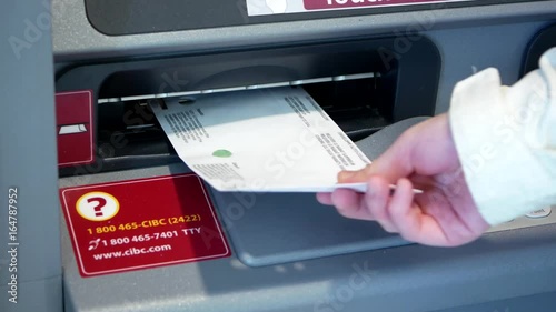 Motion of woman inserting envelop to deposit money at Cibc bank photo