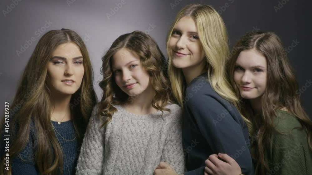 Close up shot of portrait of four sisters smiling together in studio / Cedar Hills, Utah, United States Close up shot of portrait of four sisters smiling together in studio / Cedar Hills, Utah, United States
