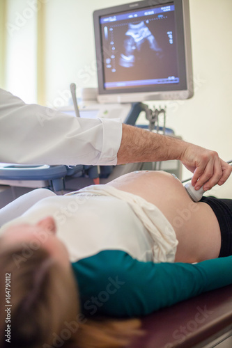 Pregnant woman checked ultrasound examination by a doctor