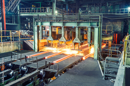 hot steel on conveyor in steel plant photo