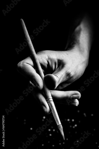 The artist's hands hold a brush