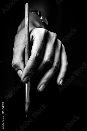 The artist's hands hold a brush