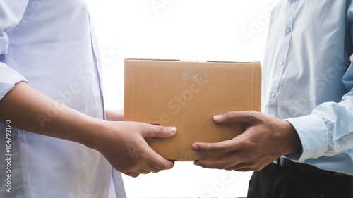 Close up hand of asia woman are receive a box from delivery man in delivery service concept di-cut on white background. © boophuket