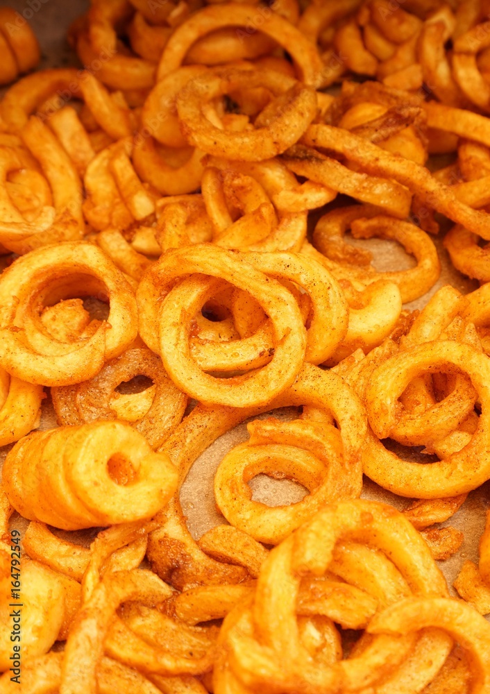 Crispy baked curly fries on a baking sheet