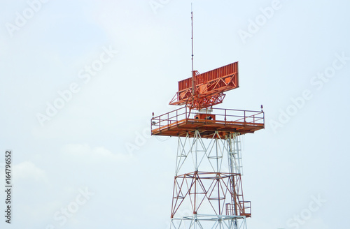Red-and-white airport radar in daylight