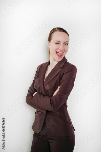 Attractive girl in a suit making faces on a white isolated background. Business concept.