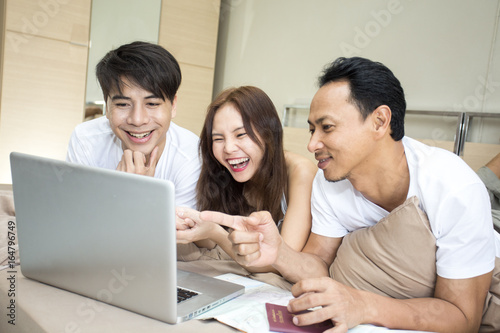 Group of man and woman using computer for seaching travel place in the room. lifestyle people concept.