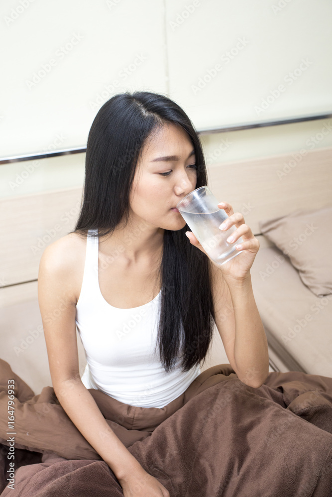 Beautiful asian woman drinking water, Young woman portrait in bedroom. Beautiful asian woman drinking water, Young woman portrait in bedroom.