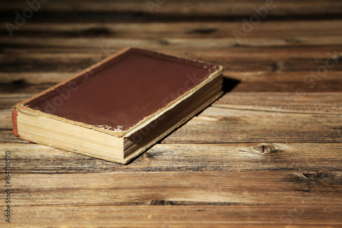 Old book on a brown wooden table