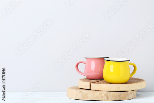 Pink and yellow mug on white wooden table