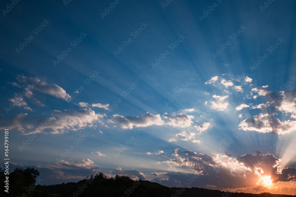 Sunset sky with sun beams bursting through the dark clouds. Conceptual meditation background. Hope, prayer, God's mercy and grace