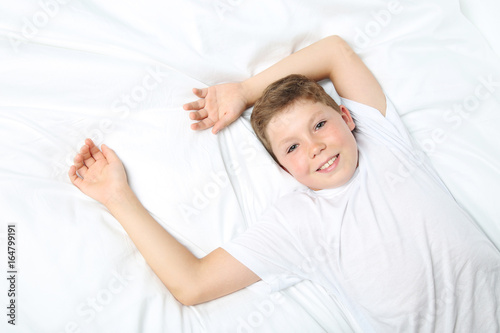 Young boy sleeping in white bed